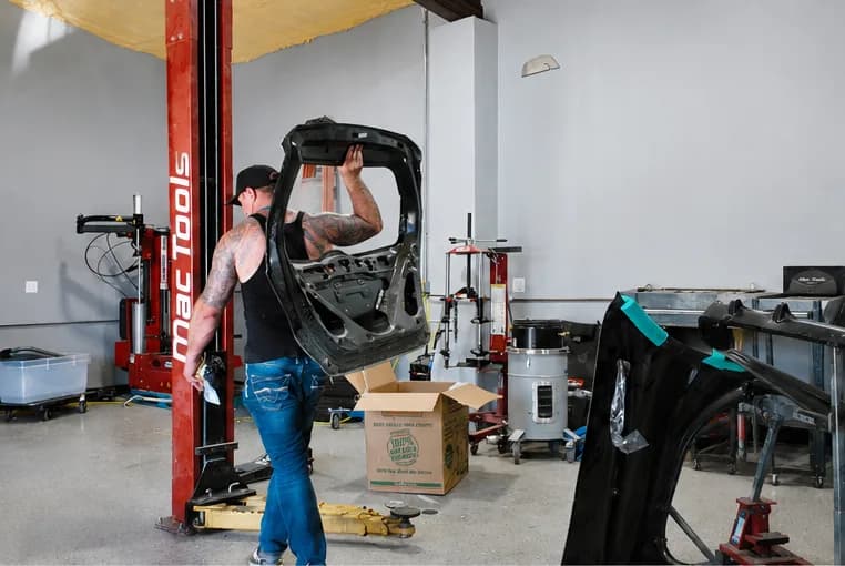 Xtreme Collision technician removing a vehicle door for a certified collision repair in Carrollton